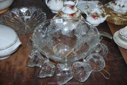 A glass Punch Bowl having 12 punch cups and a plastic ladle, bowl 12 1/2" diameter.