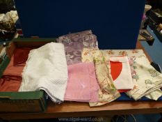 A box of fabric remnants in floral pattern, cream and burgundy.