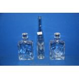A pair of heavy Studio glass type decanters and a tall vine engraved bottle.