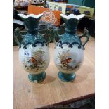 A pair of two handled vases with winter scenes to the front and floral design to the back.