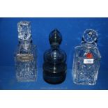 Three decanters including a Webb square decanter, a Dartington smoky glass decanter,