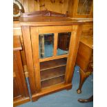 An Edwardian Mahogany music Cabinet having a carved upstand and turned finials,