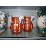 A pair of octagonal shaped Jugs in amber colour with blue and white stylized floral decoration,