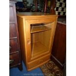 An Ercol Cupboard/Hi-fi Cabinet having glazed door to one fixed and two adjustable shelves interior