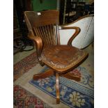 An American Oak swivel Office open armed Armchair having tilt action, four legged base,