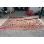 A large bordered patterned and fringed Eastern Rug in rustic red and dark blue with cream gulls,