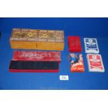 A wooden Cribbage board decorated with playing cards, Dominoes set, two sets of playing cards,