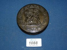 A pressed tortoiseshell circular snuff box decorated with two putti under a tree,