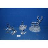 A trio of glass swans plus another and a glass stag ornament.