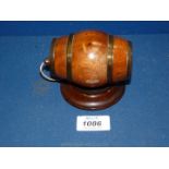 A treen walnut string barrel with brass hoops on a circular rosewood base.