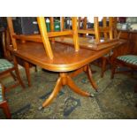 A contemporary Mahogany finished cross-banded with Yew wood double pedestal Dining Table on three