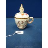 A Meissen chocolate cup, having a small chip to the finial,