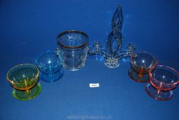 Four coloured glass dessert bowls, glass candlesticks and an ice bucket.