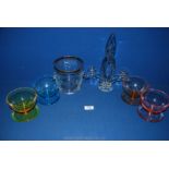 Four coloured glass dessert bowls, glass candlesticks and an ice bucket.