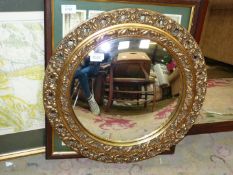 A gilt framed oval mirror. 20" diameter.