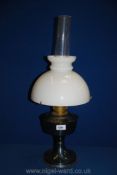 An Oil Lamp with blue metal base, and white shade,
