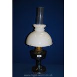An Oil Lamp with blue metal base, and white shade,