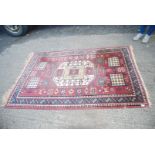A bordered patterned and fringed Rug with large central gulls on dusty red background,