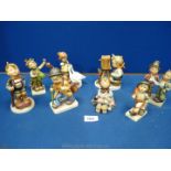 Six Hummel figures including a boy with a cello, carol singers, and a boy with a camera,