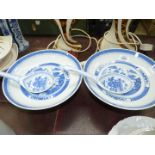 A pair of blue and white oriental footed serving Dishes and serving spoons.