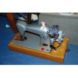 A cased hand sewing machine;