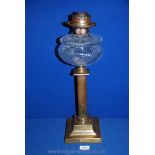 A Brass Oil Lamp with clear cut glass oil reservoir standing on reeded column,