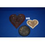Three old wax plaques; two being heart shaped in floral pattern and one circular.