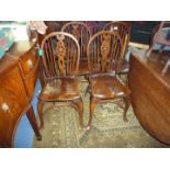 A good set of four solid Elm seated wheelback Dining Chairs having turned back legs and cabriole