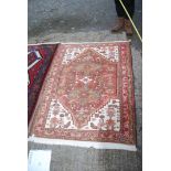 A bordered patterned and fringed Rug in brown and cream geometric pattern with pink border,