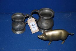 Two pewter tankards; 1/2 pint and 1/4 pint and a brass pig.