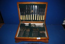 A 1930's dark oak cutlery canteen with bone handles and contents.