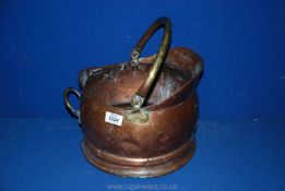 A copper coal bucket with brass handles.