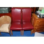 A pair of maroon leather effect upholstered high-backed side/dining chairs.