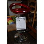 A chromium plated based and metallic red plastic seated adjustable bar stool.