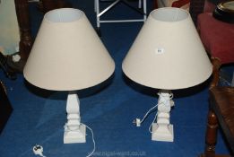 A pair of painted wood table lamps with cream shades.