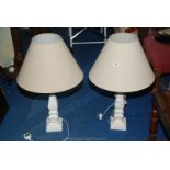 A pair of painted wood table lamps with cream shades.