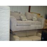 A beige upholstered two-seater settee.