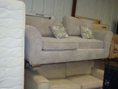 A beige upholstered two-seater settee.