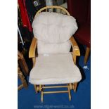 A modern light-wood Rocking Chair with removable covers/cushions.