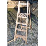 A wooden three-tread decorator's step ladder.