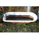 A cast iron bath with brass taps.