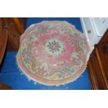 A fringed, circular floral decorated hearth rug. 4' diameter.