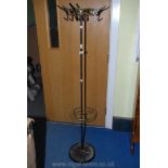 A metal hat and coat stand incorporating a stick/umbrella stand to the base.