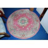 A pink floral circular hearth rug, 4' diameter.