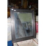 A wall-hanging rectangular framed mirror having a metallic type finish. 29'' x 36''.