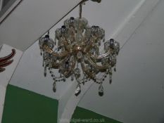 A metal framed eight branch chandelier with glass cups and droppers.