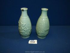 A pair of jade green coloured oriental Vases depicting two men in a field,