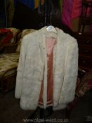 A ladies white rabbit fur Jacket with pink acetate lining.