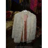 A ladies white rabbit fur Jacket with pink acetate lining.