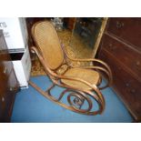 A bentwood framed Rocking Chair with caned seat and back.